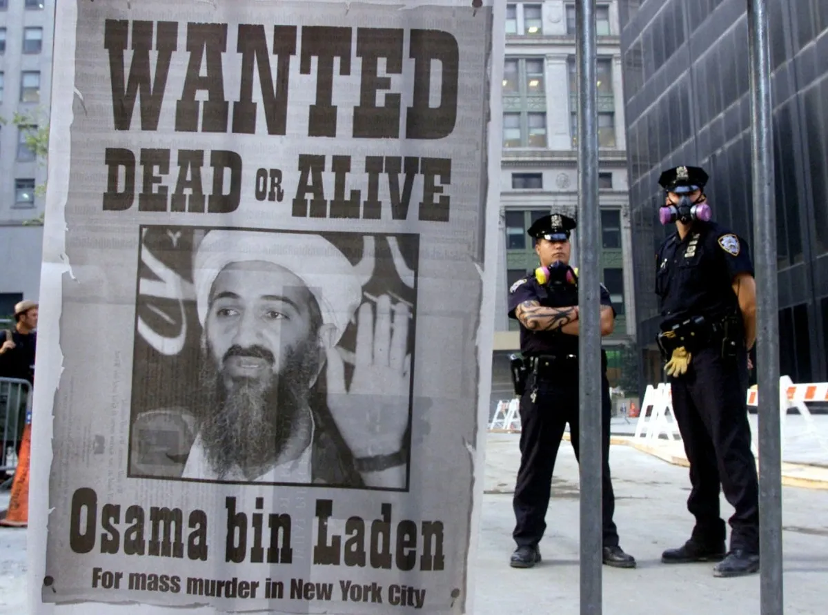 Cảnh sát đứng gần tấm áp phích truy nã Osama bin Laden vào ngày 18/8/2001. Thủ lĩnh al Qaeda sau đó bị giết trong cuộc đọ súng với lực lượng Mỹ ở Pakistan vào ngày 1/5/2011, kết thúc cuộc truy lùng kéo dài gần 10 năm trên toàn thế giới để tìm ra kẻ chủ mưu vụ tấn công 11/9.