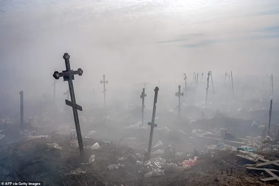 Các Thánh giá Ukraine được in hình dưới khói và rác tại nghĩa trang Mykolaiv, miền nam Ukraine.