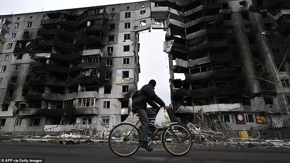 Một người đi xe đạp đi ngang qua một tòa nhà bị phá hủy ở thị trấn Borodianka, phía tây bắc Kiev.