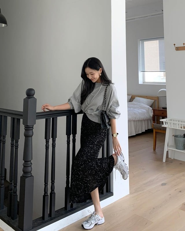 Áo nỉ màu xám với chân váy kim tuyến tạo nên một outfit thu hút ánh nhìn.
