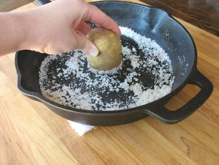 Gọt vỏ khoai tây, rửa sạch và để ráo nước, sau đó cắt đôi củ khoai tây.