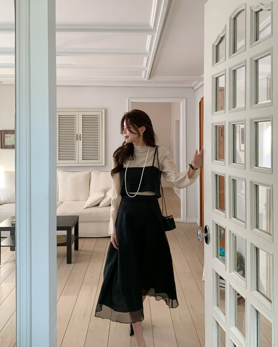 Sự kết hợp layer đầy phong cách với áo crop top hai dây và chân váy chữ A đen mang đến vẻ ngoài cá tính