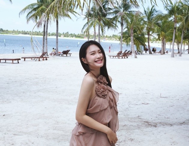 Doãn Hải Mỹ với nụ cười tỏa nắng trên bãi biển.
