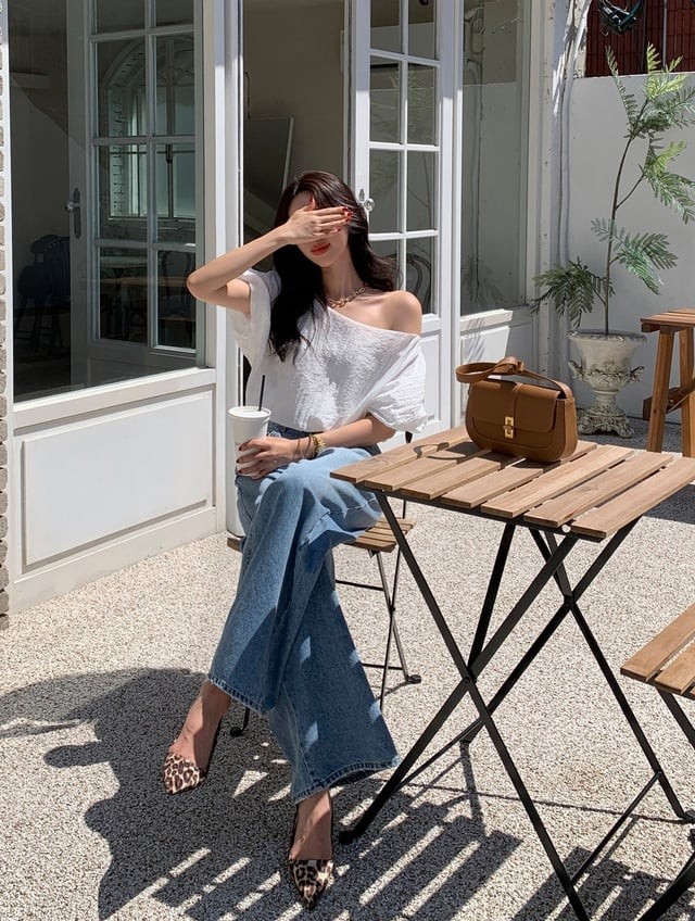 Một trong những công thức được nhiều người đẹp ưa chuộng chính là mix quần jeans xanh cùng áo blouse trắng lệch vai. 