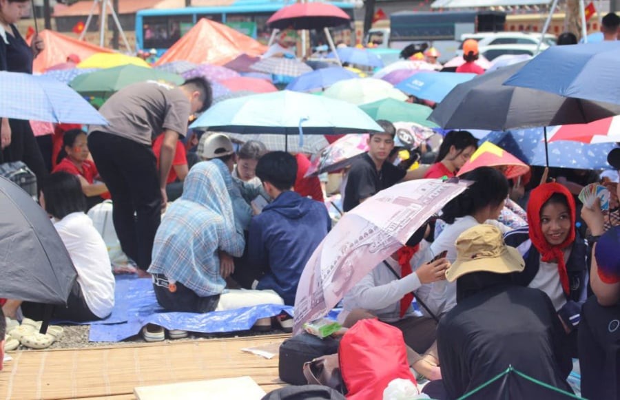 Người dân chuẩn bị chiếu, phông bạt, ô, đồ ăn, nước uống... đến khu vực các khối diễu binh, diễu hành để chờ đợi từ sáng sớm.