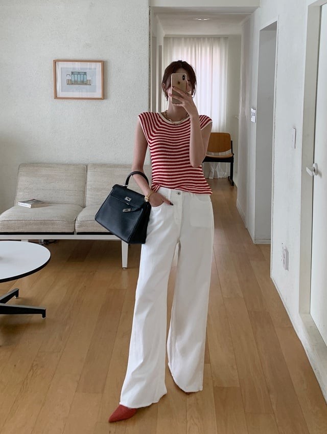 Mẫu áo len kẻ đỏ – trắng khi phối với quần jeans trắng mang lại vẻ tươi sáng, rạng rỡ.