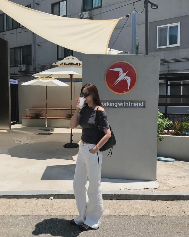 Bộ đôi áo len cổ chữ V màu đen kết hợp quần kaki xám mang lại vẻ nhã nhặn