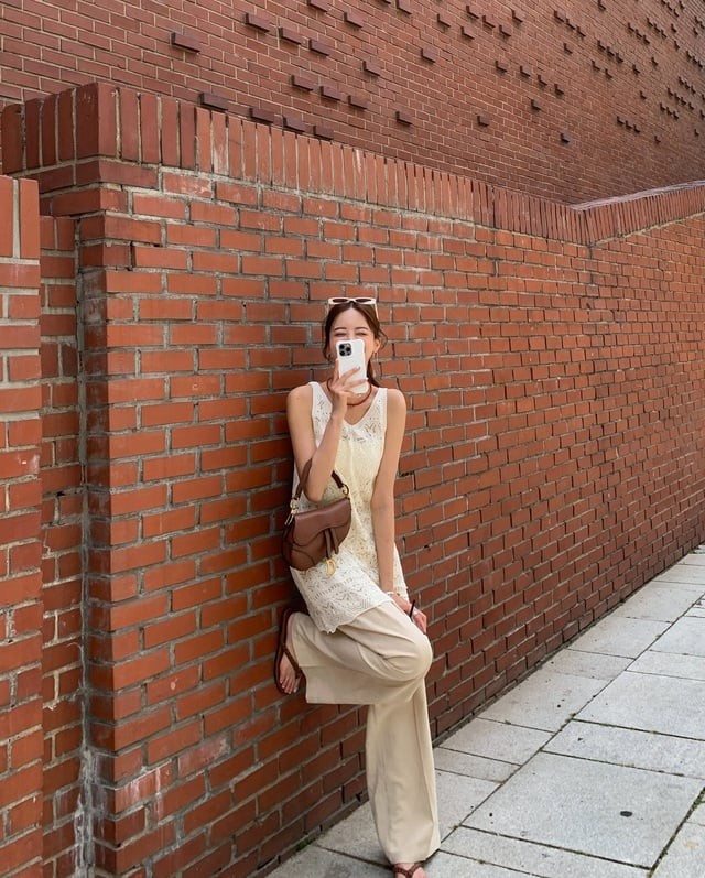 Áo gile đan móc dáng dài là tâm điểm của set đồ khi mix cùng quần ống suông.