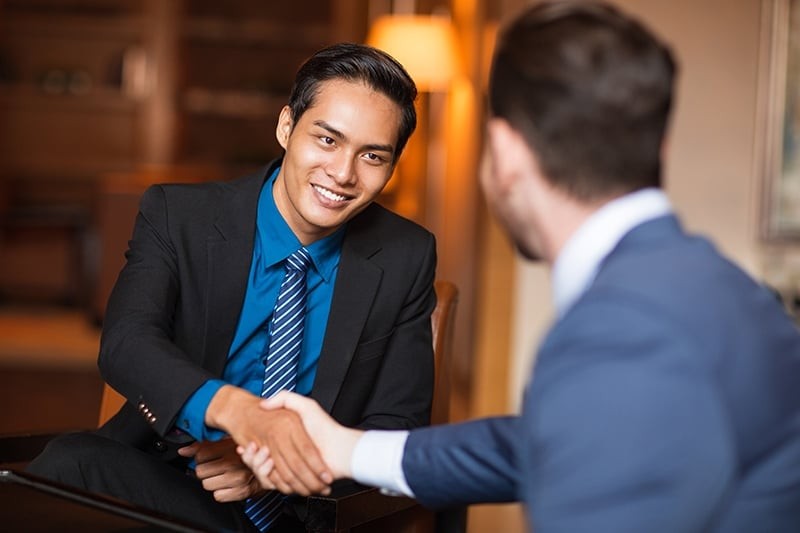 two-smiling-business-partners-shaking-hands