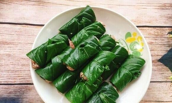 Trải lá xương sông ra mặt phẳng thớt hay mâm cho sach, múc lượng nhân phù hợp vào rồi cuốn lại
