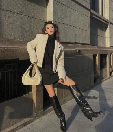 Bí quyết nằm ở việc điều chỉnh độ dài giữa boots và váy để khoảng hở ở giữa vừa đủ, giúp đôi chân trông dài hơn. 
