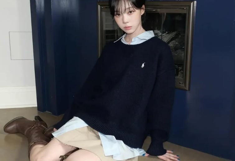  Winter kết hợp áo sơ mi trắng với sweater trầm màu, chân váy khaki ngắn và boots cao cổ da nâu.