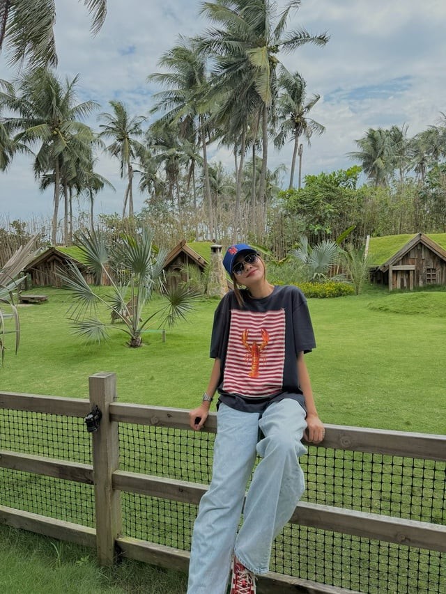 Cô chọn áo thun in họa tiết phối cùng quần jeans xanh dáng rộng, vừa năng động vừa trẻ trung.