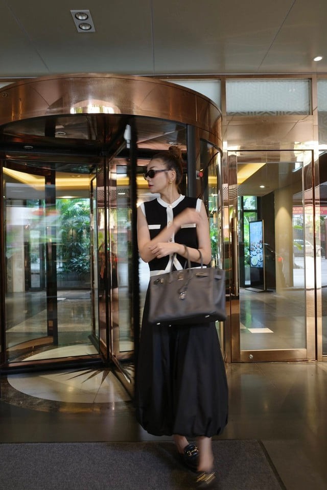 Cô lựa chọn loafer hở gót cùng túi xách màu trung tính, giúp tổng thể đồng bộ và đẳng cấp.