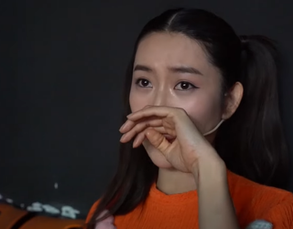 Thúy Ngân ngồi co ro một góc, cúi mặt khóc nức nở.