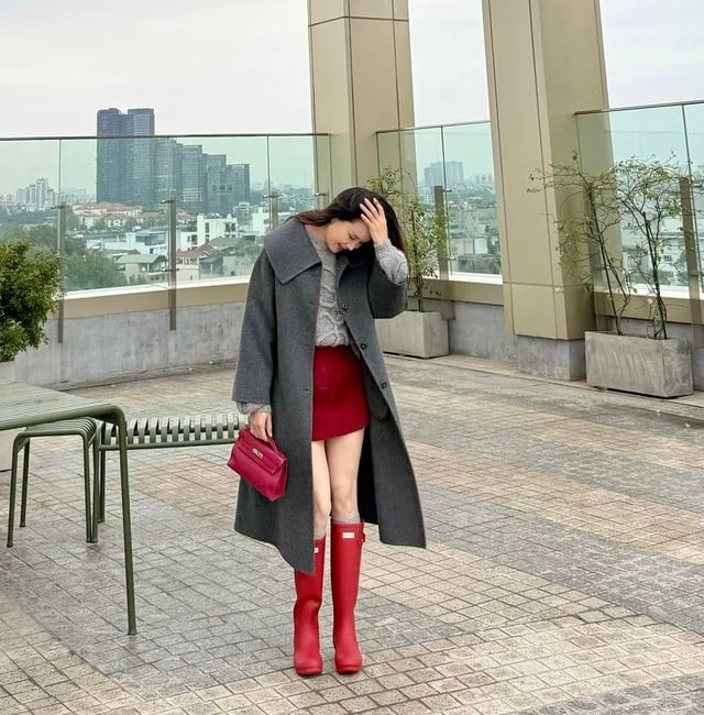 Hồng Diễm nhanh chóng “bắt sóng” với cách phối tinh tế giữa áo len xám, chân váy ngắn, túi xách đỏ và boots cao cổ.