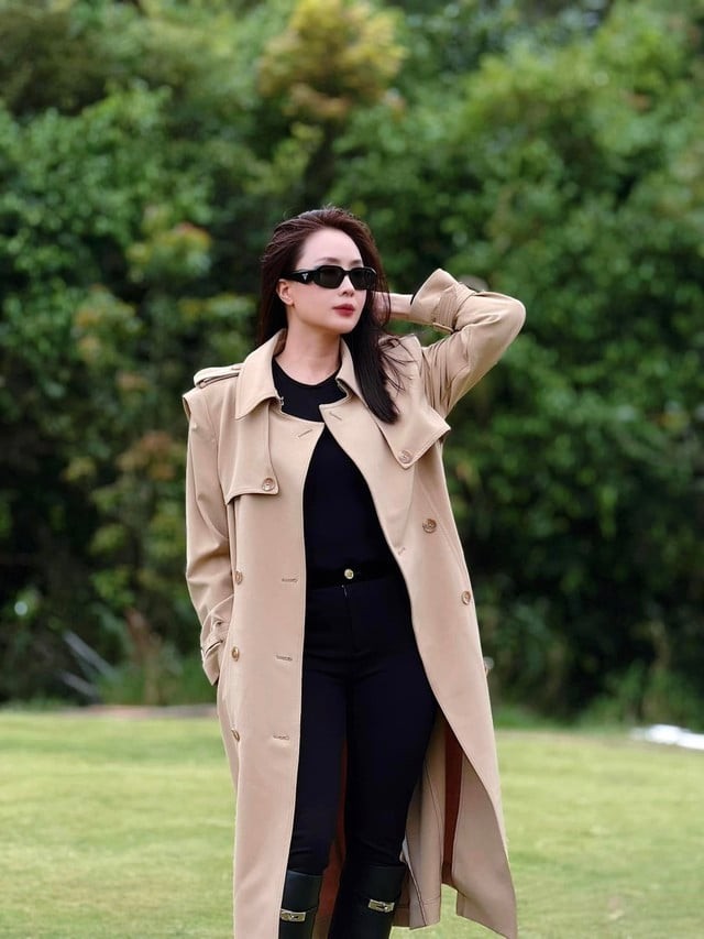 Cô kết hợp trench coat màu be cùng áo thun, quần skinny và boots đen – công thức đơn giản nhưng tạo hiệu ứng thanh lịch