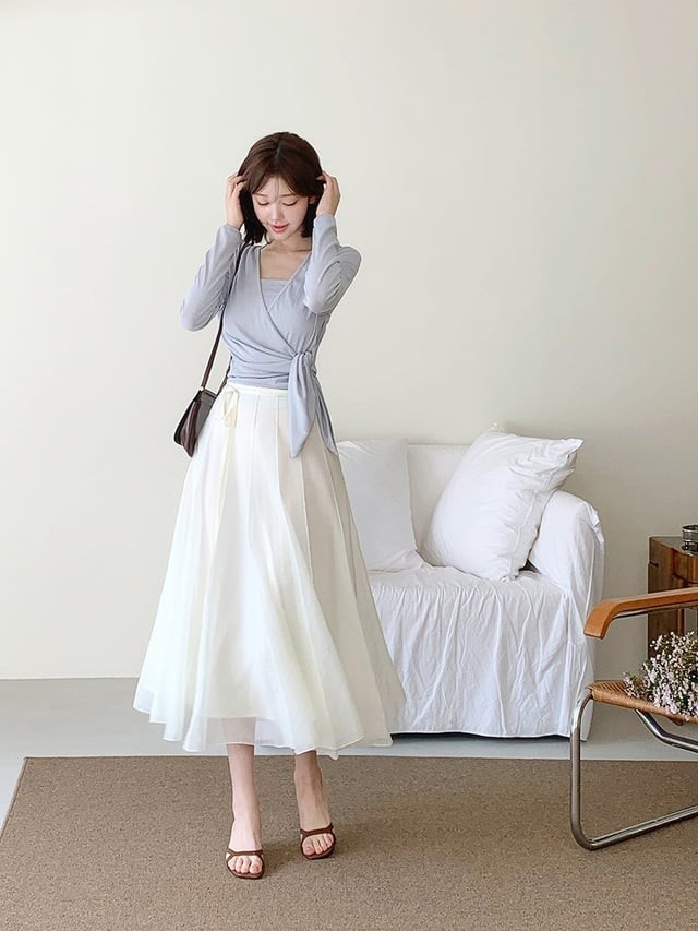 Áo cổ chữ V có chi tiết thắt eo khi phối cùng chân váy trắng chữ A sẽ tạo nên dáng người mềm mại, nữ tính hơn. 