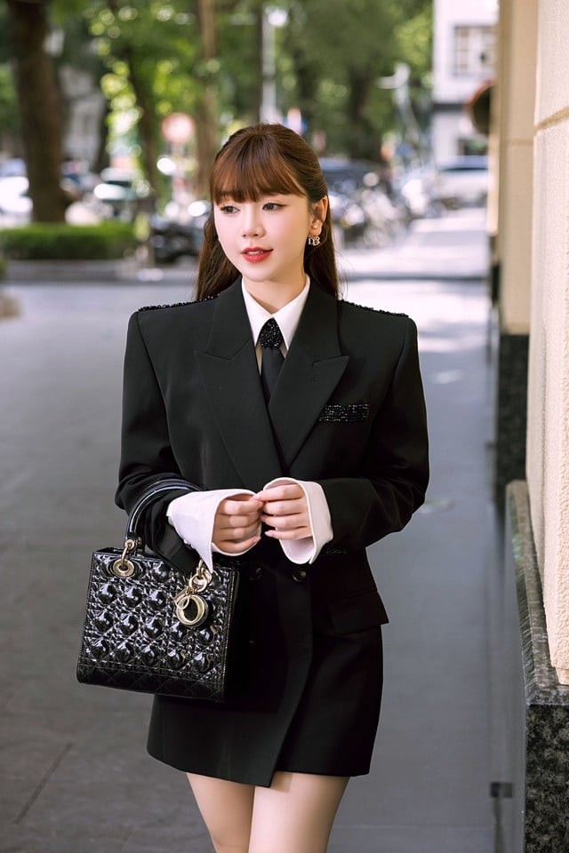 Chiếc sơ mi trắng và cà vạt layer bên trong là điểm nhấn giúp cô thêm phần hiện đại và cuốn hút.
