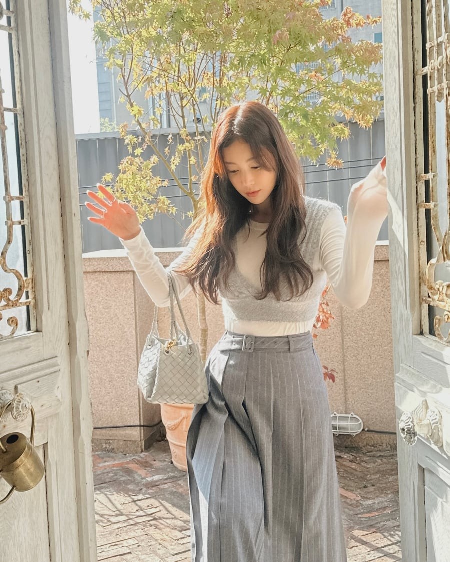 Áo thun trắng kết hợp quần âu kẻ tông xám mang đến vẻ ngoài thanh lịch và hiện đại.