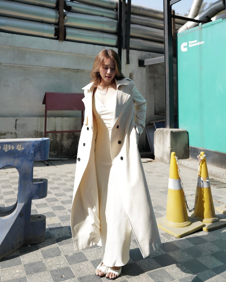 Váy dài màu trắng phối cùng trench coat trắng tiếp tục khẳng định sức hút của gam màu trung tính.
