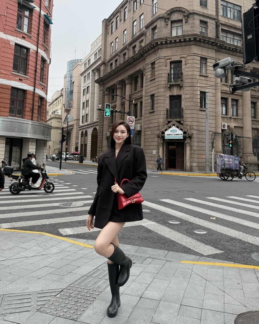 Boots cao cổ và chiếc túi đỏ là hai chi tiết giúp outfit của cô thêm sắc sảo mà vẫn đúng tinh thần mùa lạnh.