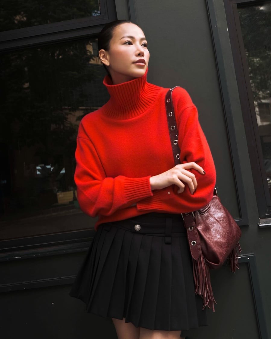 Cũng mang không khí lễ hội đậm nét, Phương Khánh chọn chân váy xếp ly phối với áo len đỏ, tạo sự rực rỡ