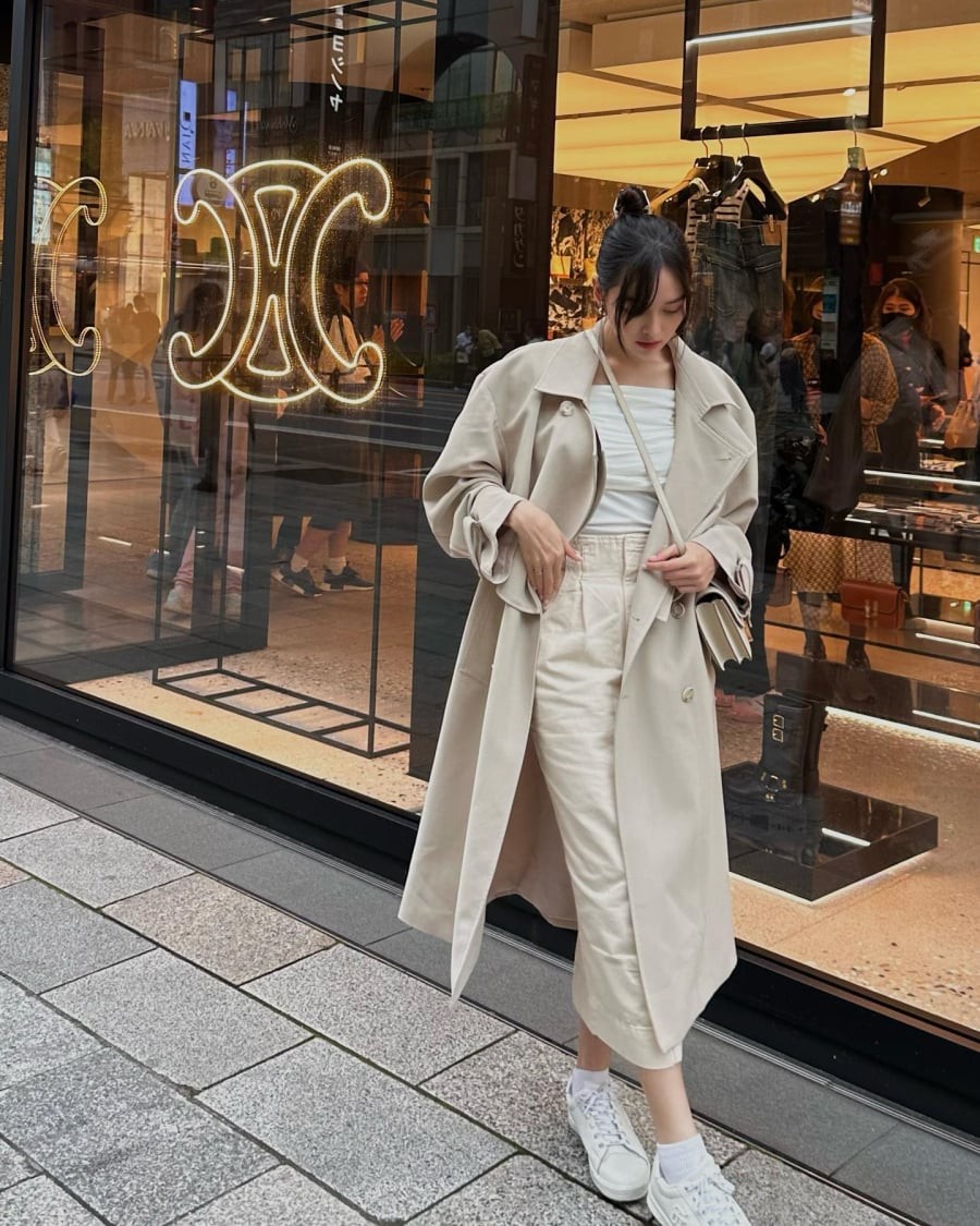 Áo trench coat vẫn có thể mang lại vẻ ngoài mềm mại nếu được phối với chân váy suông và áo thun trắng. 