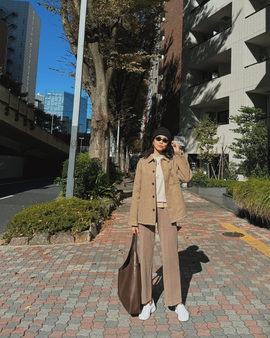 Giày xám tạo sự năng động, trong khi túi xách nâu bổ sung chiều sâu cho outfit, khiến tổng thể thêm cân bằng và có điểm nhấn.