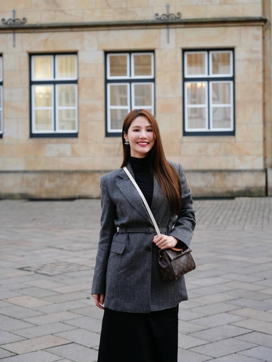 Điểm cân bằng nằm ở chân váy đen dáng dài, giúp tổng thể trở nên dịu dàng và trang nhã hơn.