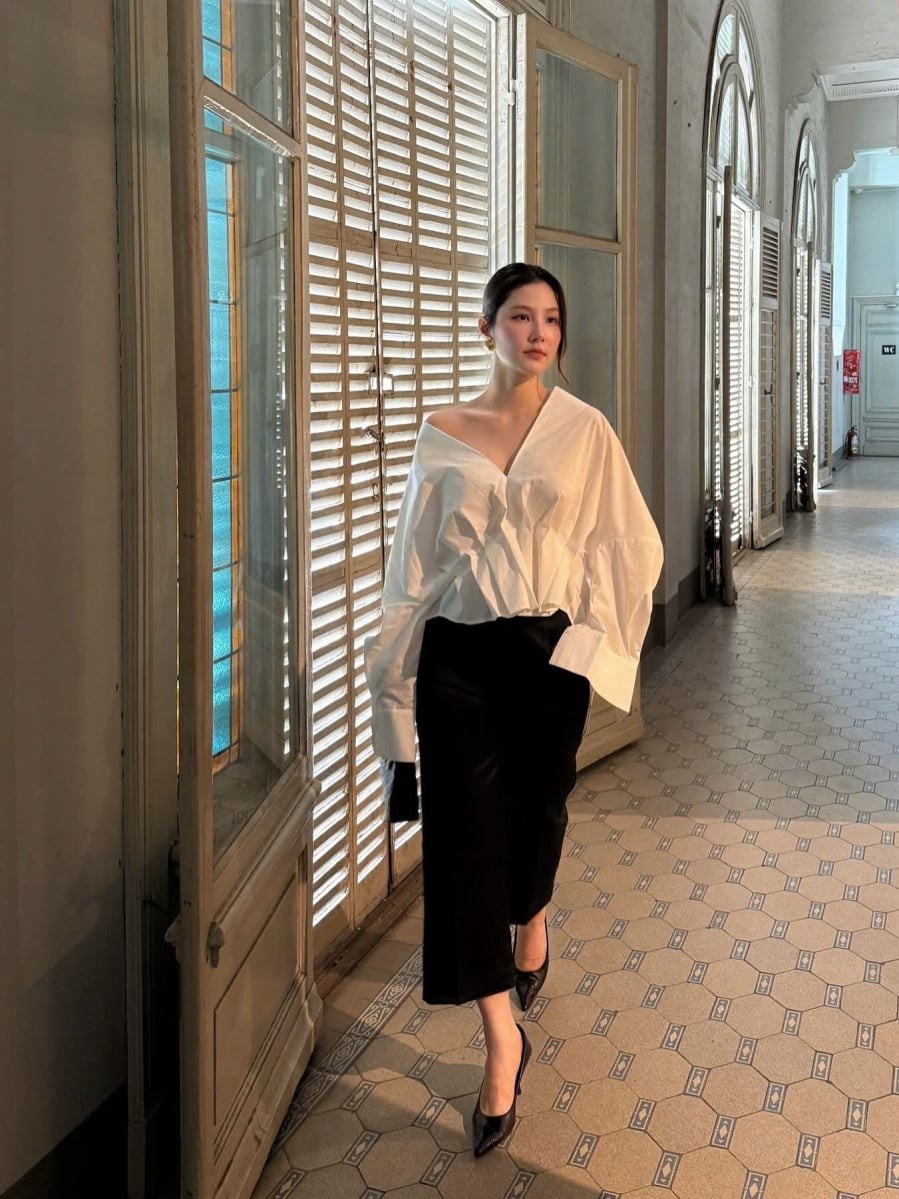 Set đồ gồm áo blouse lệch vai kết hợp quần âu dáng lửng mang đến hình ảnh quý phái và thời thượng. 