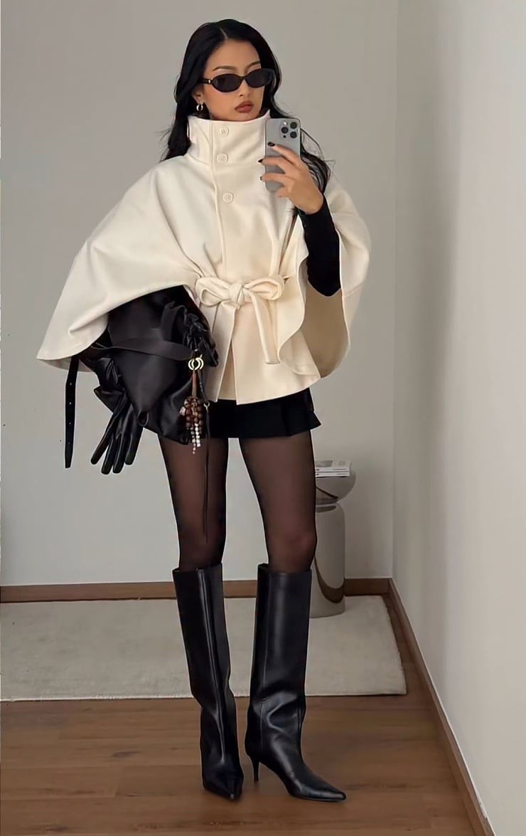 Chân váy len ngắn phối cùng áo khoác dáng cape hoặc áo cổ phễu tay loe, có thắt đai là lựa chọn phù hợp với những ai muốn làm nổi bật đôi chân.