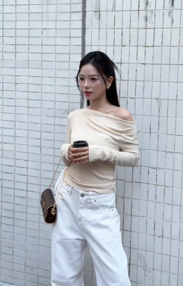 Dù sử dụng hai gam màu quen thuộc là be và trắng, trang phục vẫn trở nên nổi bật nhờ thiết kế áo lệch vai mang lại nét mềm mại, nữ tính.