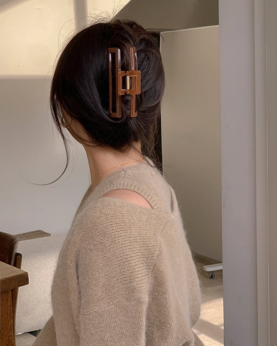 Việc xoắn gọn tóc và cố định phía sau đầu tạo cảm giác gọn gàng, trong khi những lọn tóc buông nhẹ ở hai bên giúp diện mạo không bị cứng