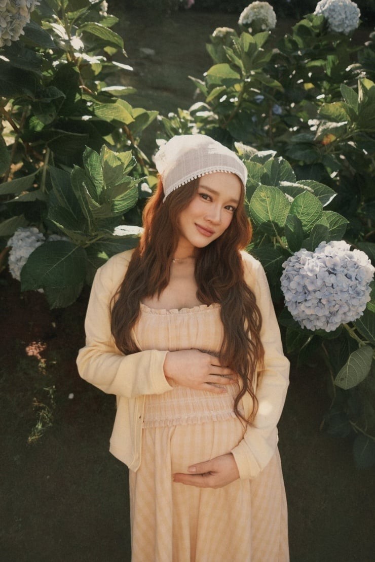 Ở một set đồ, Nhã Phương diện váy hai dây xếp nếp với phần eo ôm nhẹ, giúp vòng bụng bầu trở thành điểm nhấn tự nhiên mà không hề phô trương.