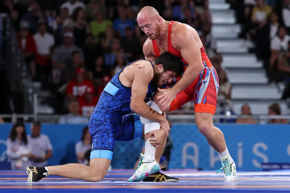 Akhmed Tazhudinov (áo đỏ) và Kyle Snyder (áo xanh) trong một cuộc đối đầu tại Olympic Paris 2024.
