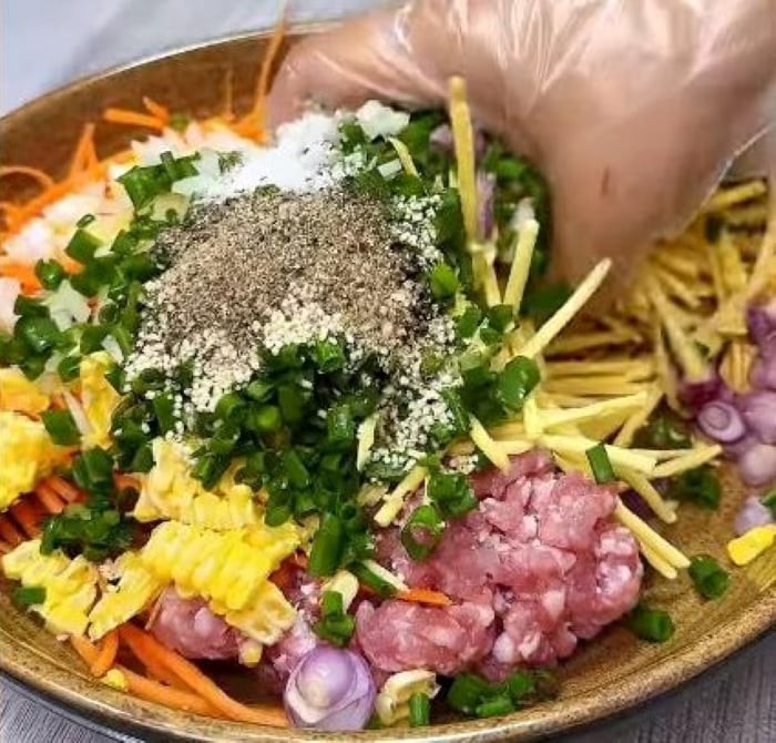 Trộn thật đều tay để gia vị thấm quyện vào từng thành phần.