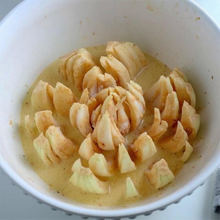 Nhúng hành tây vào hỗn hợp trứng và sữa sao cho đều