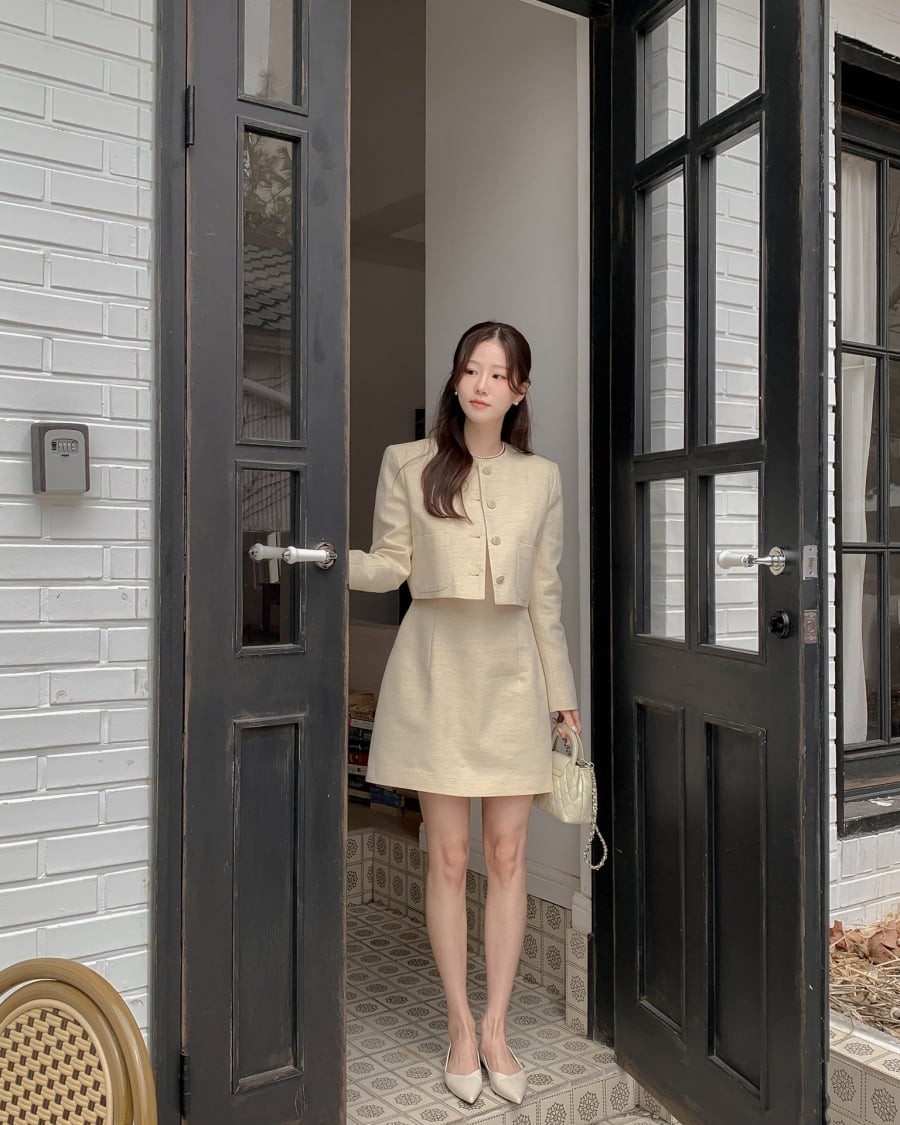 Các chất liệu như tweed, dạ mỏng hoặc cotton dày giúp trang phục giữ phom tốt, mang lại cảm giác gọn gàng và cao cấp. 