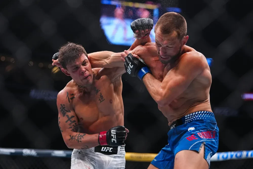 Charles Oliveira kiểm soát Max Holloway trên sàn đấu tại UFC 326