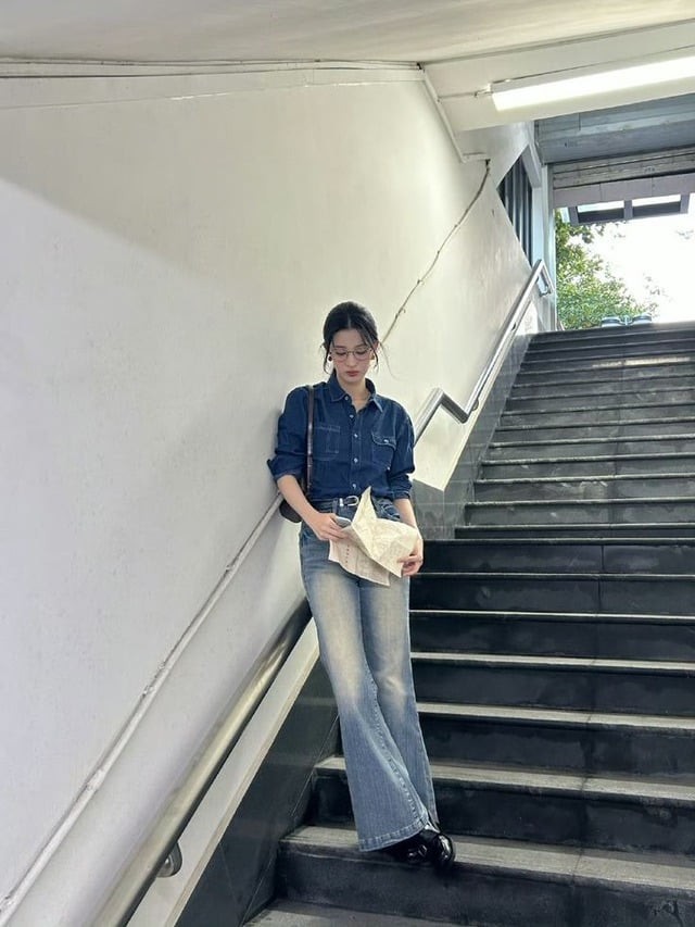 Một trong những cách phối đồ quen thuộc của cô là kết hợp áo sơ mi denim cùng quần ống loe rộng.