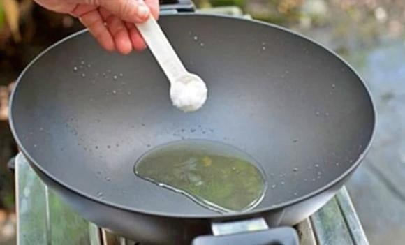 Cho một ít muối hạt vào chảo dầu và đảo đều trước khi chiên.