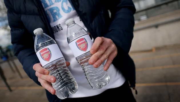CĐV Man City mua chai nước có in logo Arsenal bên ngoài sân vận động Etihad.
