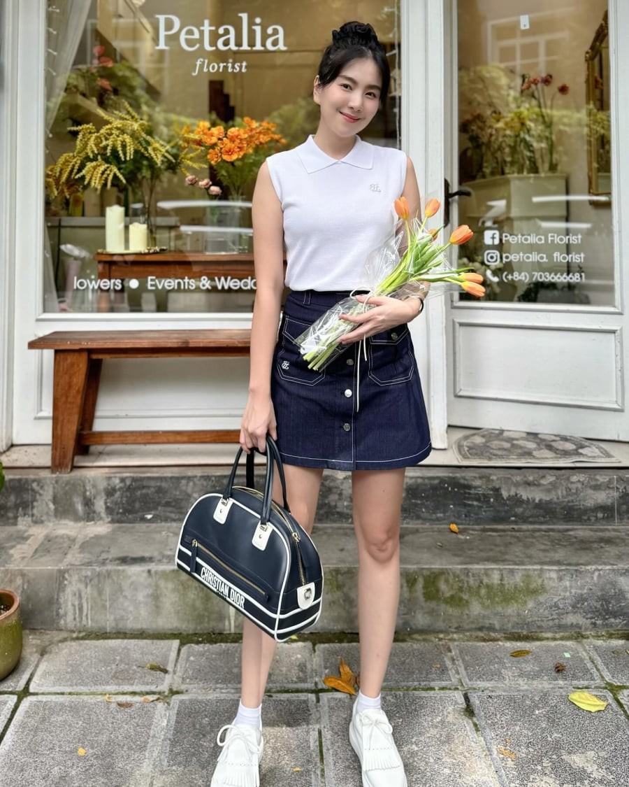 Sự kết hợp giữa áo gile trắng và chân váy ngắn mang đến hình ảnh năng động nhưng vẫn giữ được nét nữ tính. 