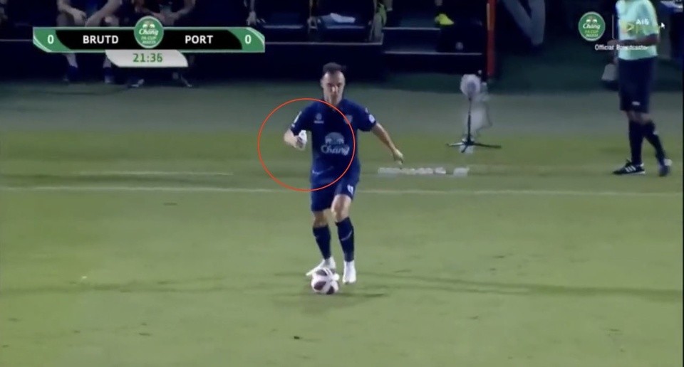 Hậu vệ Malaysia đá bóng với chai nước trên tay - Bóng Đá