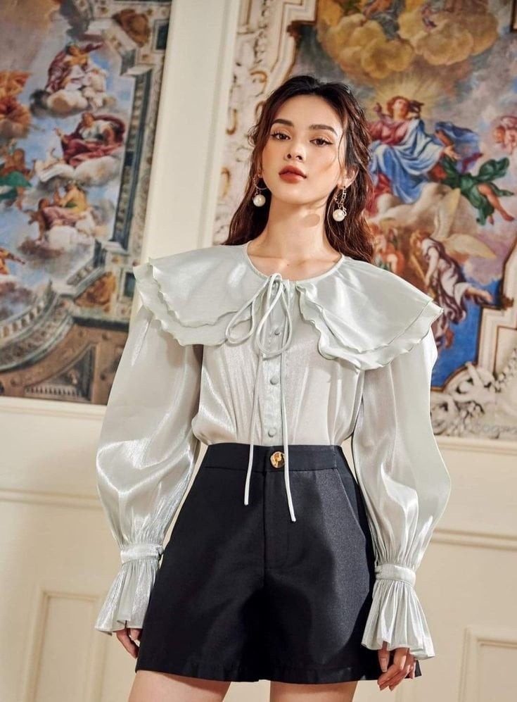 Những chiếc blouse với chi tiết nhẹ như bèo nhún, tay phồng hoặc cổ nơ giúp tổng thể trang phục trở nên duyên dáng mà không quá cầu kỳ.