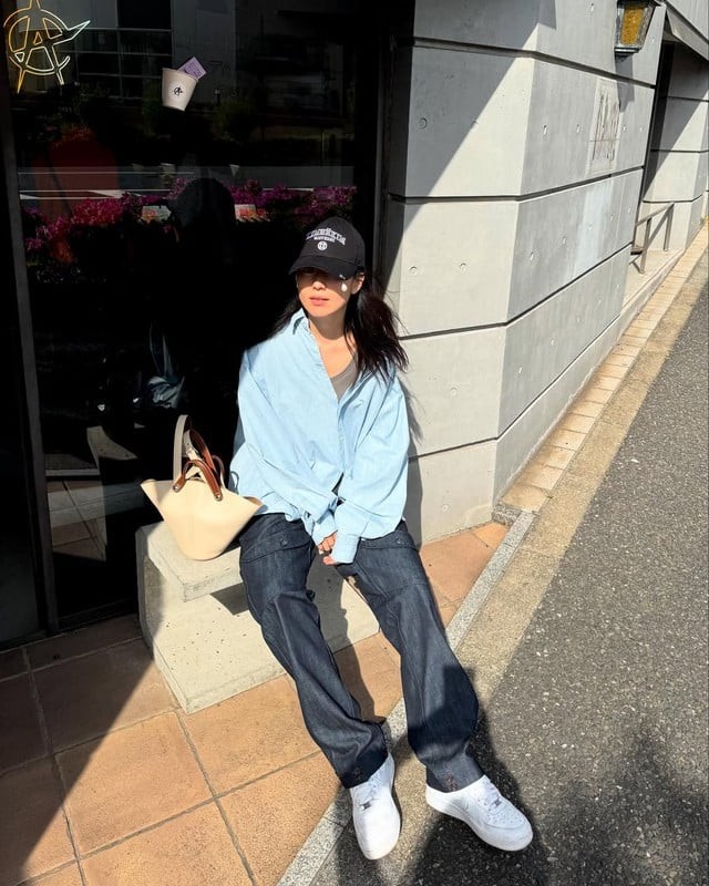 Một trong những công thức xuất hiện thường xuyên là quần jeans xanh phối cùng áo sơ mi oversized.
