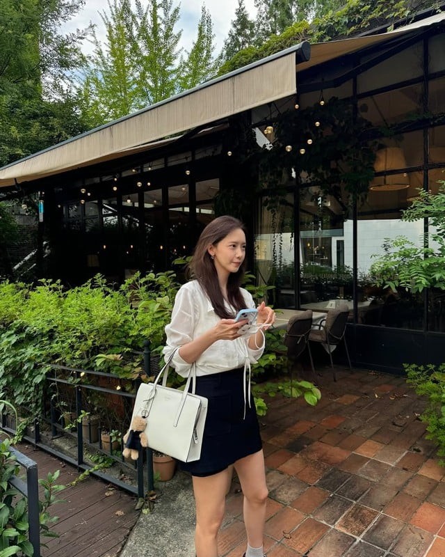 Công thức sơ mi trắng phối cùng chân váy ngắn màu đen là ví dụ điển hình cho phong cách thanh lịch nhưng vẫn trẻ trung của nữ thần tượng.