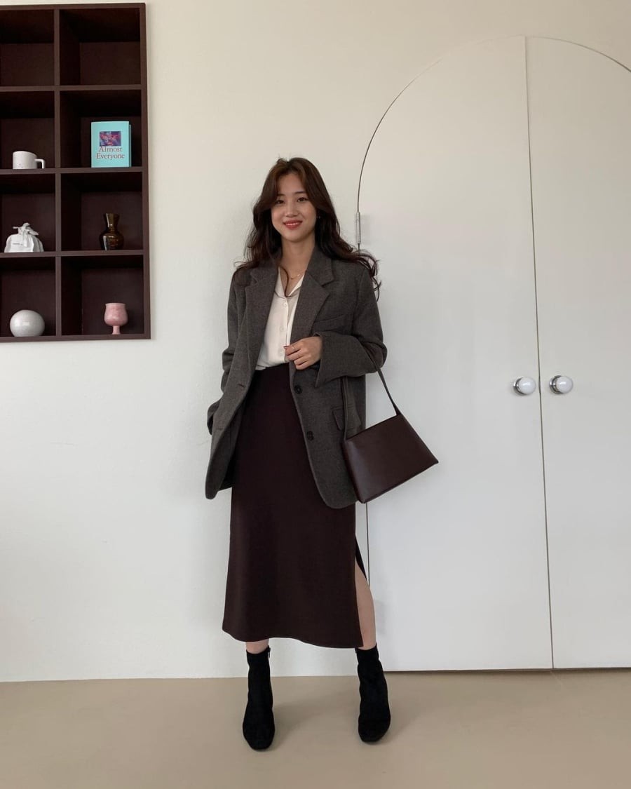 Sự kết hợp giữa phom dáng cứng cáp của blazer và nét mềm mại của chân váy tạo nên diện mạo chuyên nghiệp nhưng không hề khô cứng.