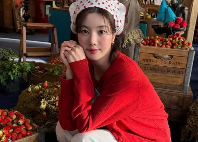 Kwon Eun Bi lại chọn phong cách trẻ trung với áo cardigan đỏ dâu kết hợp phụ kiện họa tiết trái cây. 